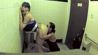 Two bitches are in the public bathroom, licking one another