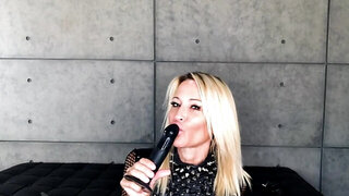 Jessica Drake uses a black dildo to show how she blows a cock