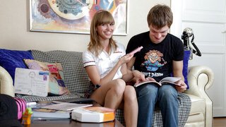 Two teens sexually exploring their bodies while on a couch
