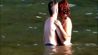 Horny couple having some fun in the water at the beach