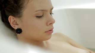 A young woman is taking a bath alone and she is relaxing