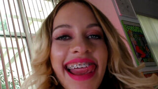 Blonde woman with braces is having fun with a big one