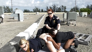 Black stud and two female cops are fucking on the roof