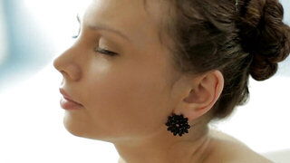 A thin lady is naked in the tub and she is all alone wit hher toy