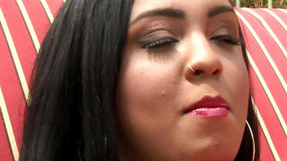 A black woman that has red lingerie on is naked outside in the sun