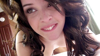 A cute thing is on her knees and she is sucking a large dick