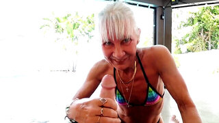 GILF gives a blowjob and a handjob in a poolside video