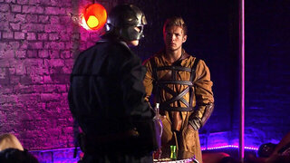 A sexy body painted girl is giving a blow job to a guy in a bar