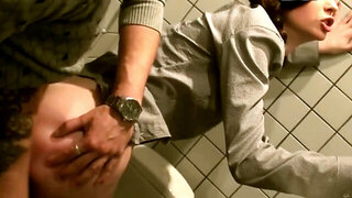 Two dicks are getting put inside a tiny woman in a public restroom