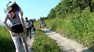 Two cocks are getting sucked on a picnic in the grass in a threesome
