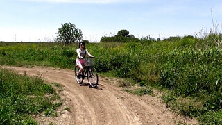 Removing her clothes while riding a bike outside