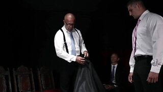 Suited men are dominating a teen with a great torso