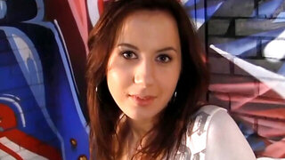 A brunette is doing a threesome and is giving a double blow job