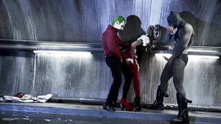 A sexy bimbo is getting fucked by two men in a batman parody scene
