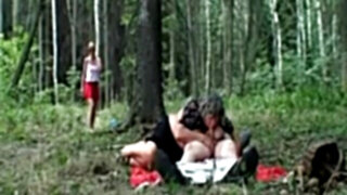 Old couple with a youthfull redhead in the forest